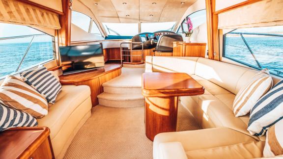 Der Salon der Funseeker-Yacht bietet cremefarbene Sofas, Holzelemente und große Fenster mit Blick auf das Meer.