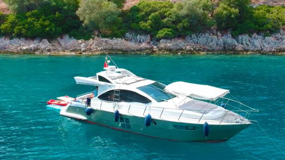 Motor yacht Germanor anchored in a quiet cove, equipped for water sports activities.