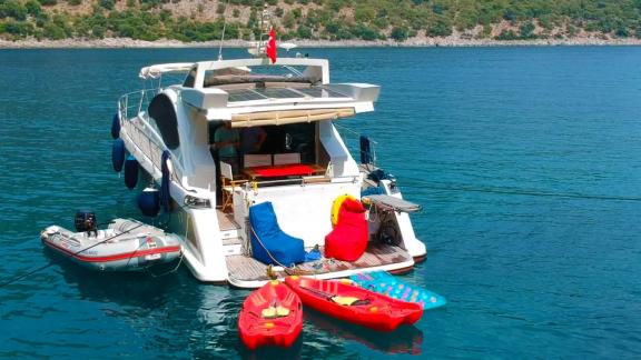 Rückansicht der Motoryacht Germanor und Wasserspielzeug, bereit für Spaß im türkisfarbenen Wasser.