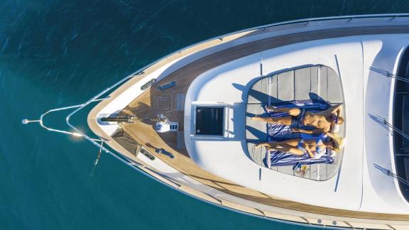 Aerial view of a couple enjoying the sun on the foredeck of the Hope I yacht.