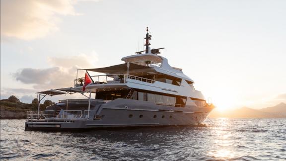 Die 131 ft Motoryacht Illusion 2 liegt ruhig vor Bodrum, während die Sonne am Horizont untergeht.