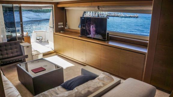 Innenraum der Motoryacht Kuum mit geräumigem Sitzbereich und Fernseher.