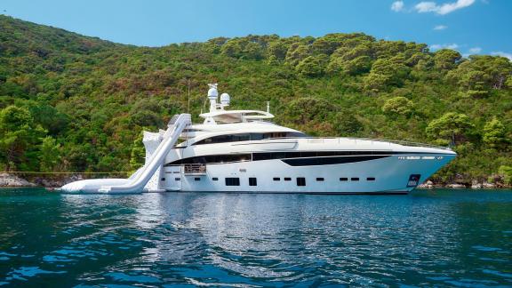 Die Yacht liegt mit Wasserrutsche bei einer grünen Küste auf Split-Route.