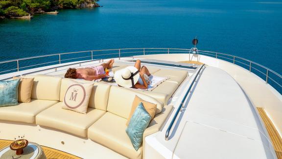 Zwei Gäste sonnen sich auf dem Vordeck der Princess 40M mit Meerblick.