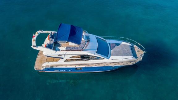 Top view of motor yacht Moonlight anchored in clear waters.