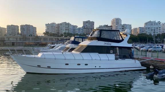 The motor yacht Niloş stands out in the harbor with its modern design.