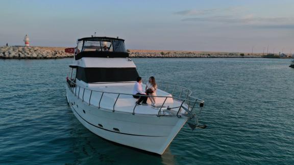 Two people are enjoying a romantic moment on the motor yacht Niloş at sunset.