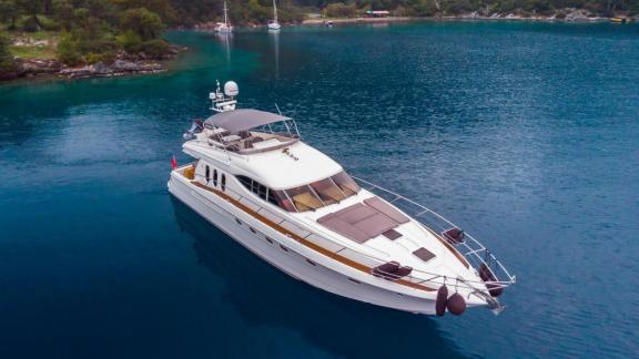 The River S motor yacht is anchored in a calm bay, offering luxury and comfort for sea lovers.