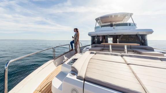 Woman enjoying the view on spacious bow deck of Sirena 64 beside comfortable cushions.