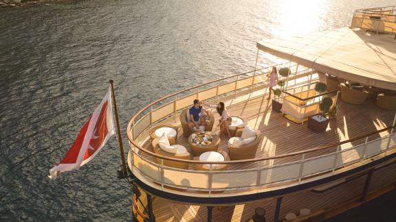 Gäste entspannen bei Sonnenuntergang auf dem Deck der Motoryacht Seagull 2 in Splits Bucht.