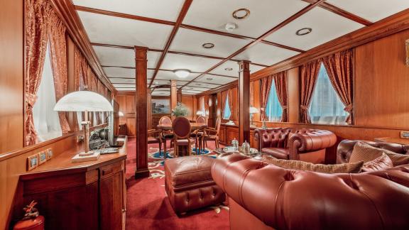 Der Salon der Motoryacht Seagull 2 mit roten Ledersofas und Holzakzenten bietet eleganten Komfort.