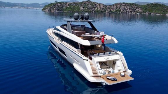 Моторная яхта Shero Ferretti 850 стоит на якоре в бирюзовых водах у Мармариса.