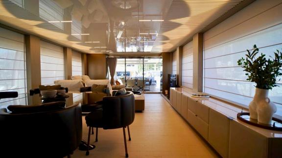 Внутренний салон Ferretti 850 Shero с диванами и обеденной зоной.