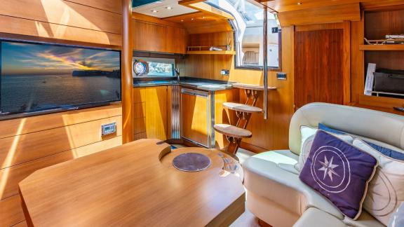 Im Salon der vor Mallorca ankernden Yacht Silencio befinden sich eine gemütliche Sitzecke und eine kleine Küche.