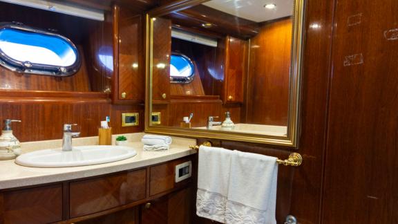 The bathroom of Sveti Sky features a sink, large mirror and polished wooden cabinets.