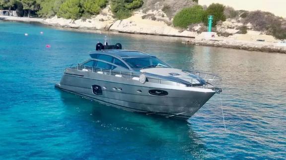 Motor yacht Urus anchored near the shore, standing out with its sleek design in turquoise waters.