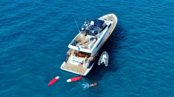 Motor yacht Riva 21 in turquoise waters with water sports equipment and swimming activity.