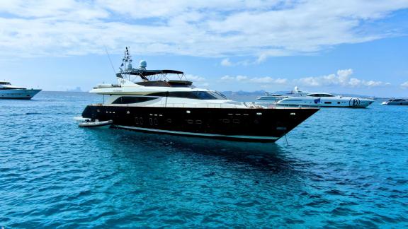 Motor yacht Usoa Bi is anchored next to another luxury yacht in turquoise waters.