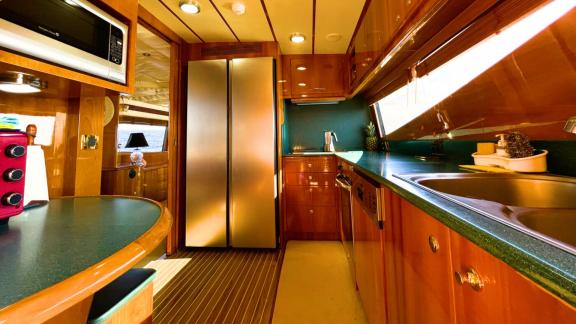 The kitchen of motor yacht Riva 21 features a large refrigerator, sink, and full kitchen equipment.