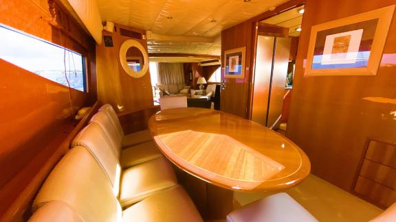 Inside motor yacht Riva 21, there is an elegant dining table with comfortable seating.