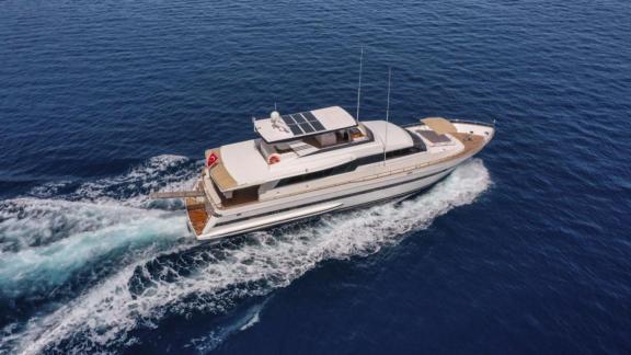 The motor yacht Vega cruising fast on the water in Göcek, featuring a spacious deck and stylish design.