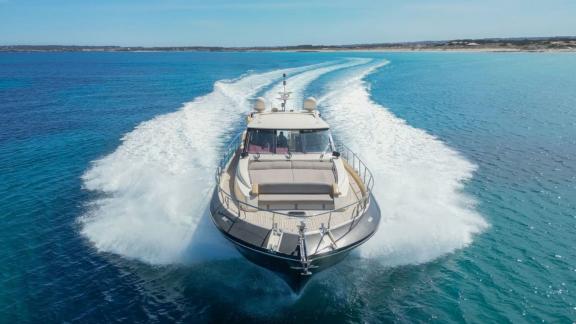 Motoryacht Vintage fährt schnell über das offene Meer und schneidet durch die Wellen.