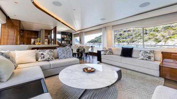 Elegant living room on a yacht with panoramic windows and sea views.