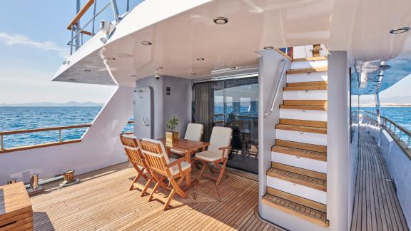 Stylish covered dining area on the motor yacht Wide Liberty with a sea view.