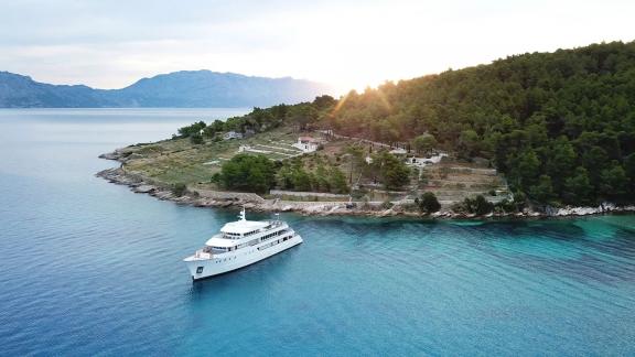 Die Motoryacht Yolo liegt vor Anker in einer ruhigen, unberührten Bucht nahe Split.