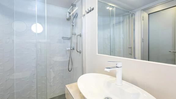 Yolos Bad bietet Duschkabine aus Glas, stilvolle Armaturen und viel Licht.