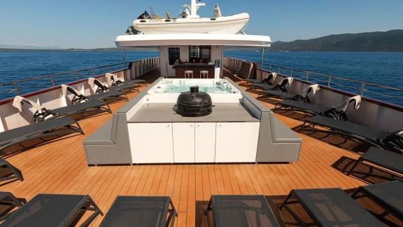 Entspannen Sie in der Sonne mit Jacuzzi, Sonnenliegen und Sitzbereich auf dem Oberdeck der Yolo.