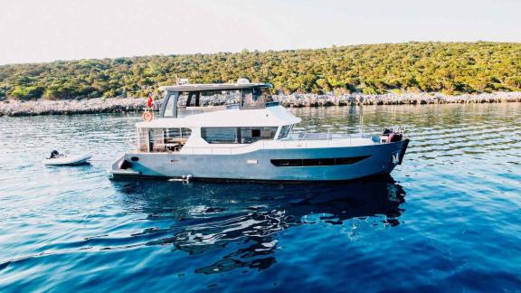 Berre Lal motoryatı Bodrum koyunda demirlemiş, yanında bir servis botu duruyor.