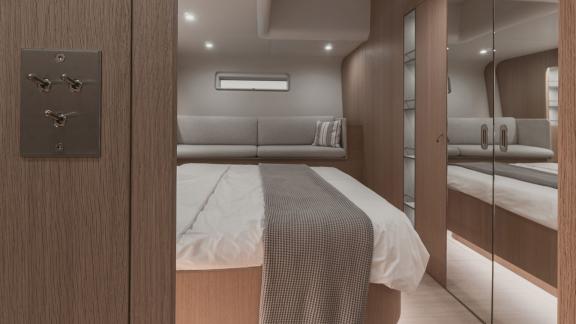 Modern double cabin on the yacht Nadamas with mirrored closets and a spacious seating area.