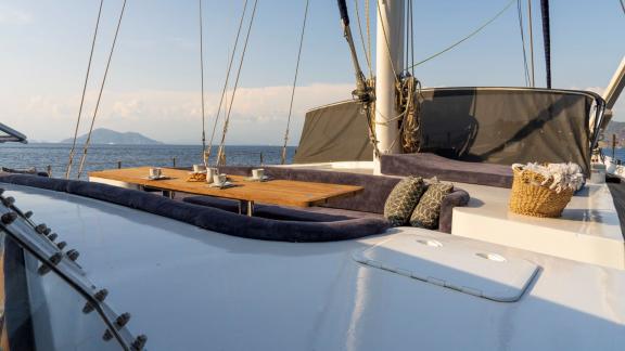 An inviting seating area with cushions and table on the deck of a 5-cabin motor yacht in Fethiye.