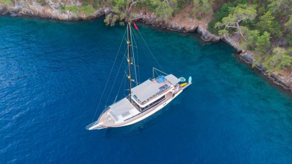 The stylish Gulet Nayk 2 anchored in a secluded bay with crystal-clear waters in Fethiye.