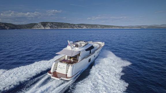 Rear view of the Panta Rei motor yacht cruising at high speed into the open sea.