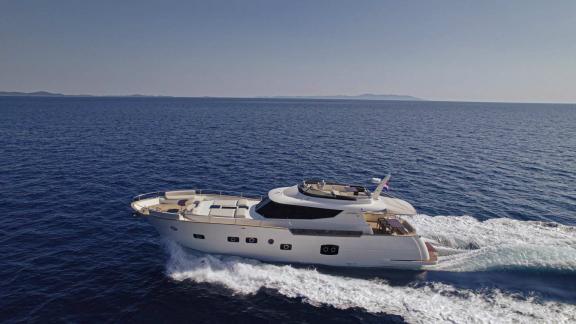 Panta Rei, an elegant motor yacht, cruising at high speed on the sea off Croatia's coast.