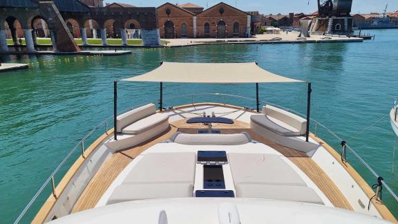 Elegant sun deck of the Panta Rei motor yacht with seating area and sunshade in Croatian harbor.