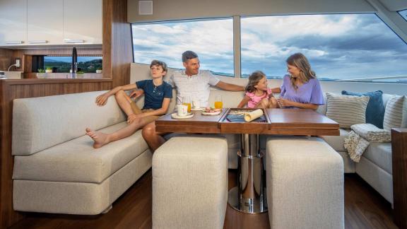 Family enjoying the modern living area of the Panta Rei motor yacht with panoramic windows and stylish design.