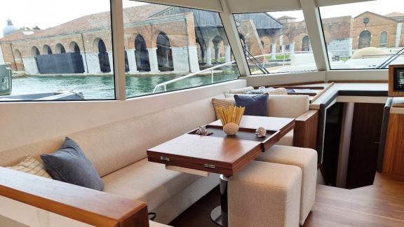 Stylish dining area and seating inside the Panta Rei motor yacht, anchored in the harbor.