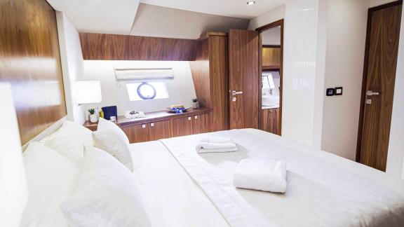 Bright and cozy bedroom on the Panta Rei motor yacht with modern amenities and stylish wood interior.