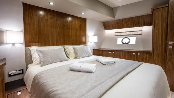 Comfortable bedroom on the Panta Rei motor yacht with stylish wood design and luxurious amenities.