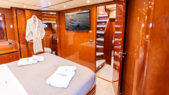 Luxuriöses Schlafzimmer auf der Yacht Pareaki mit TV, Bademantel und großem Bett.