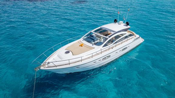 Ibiza’da demirli Fancy That motoryatın dış görünümü ve geniş güverte alanı.