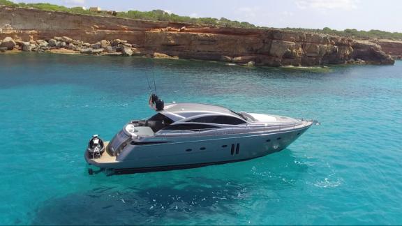 Die Yacht Optimum nähert sich einer ruhigen Küstenbucht. Perfekt für eine entspannte Pause beim Chartern.