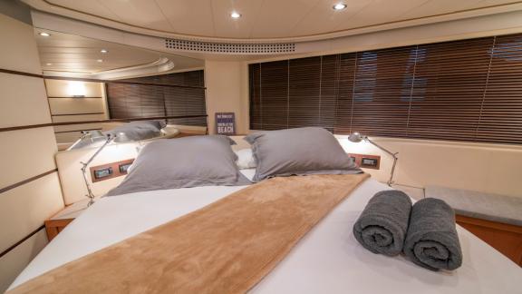 Die Kabine bietet ein großes Bett, Leselampen und dunkle Jalousien. Eine elegante Atmosphäre zum Entspannen.