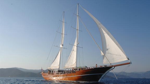 Ride on an elegant Gulet yacht against a picturesque coastal backdrop