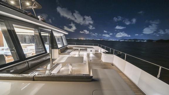 Evita power catamaran features a spacious foredeck with seating areas and open sea views.