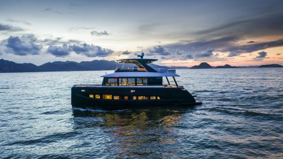 Evita power catamaran with 5 cabins for 10 guests cruising at sunset along the Athens coast.