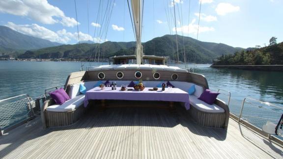 The cosy outdoor dining table at Gulet Prenses Lila, surrounded by water and mountains in Fethiye.